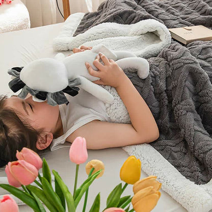A child wrapped in the gray sherpa throw blanket