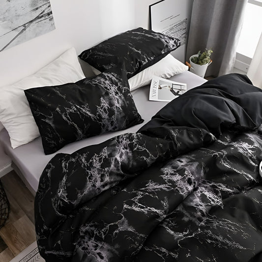 The made bed seen from the side, with both black marble pillowcases and the cover falling in soft folds.
