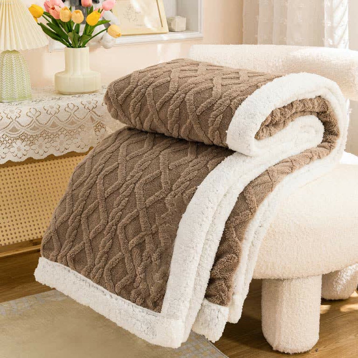 Brown sherpa throw blanket folded, the raised cable and diamond texture facing out