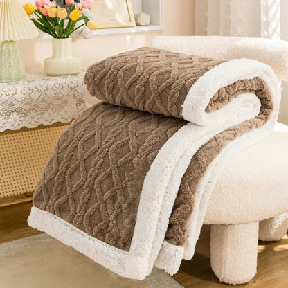 Brown sherpa throw blanket folded, the raised cable and diamond texture facing out