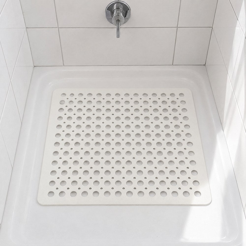 A white square shower mat sitting in the base of a white shower tray
