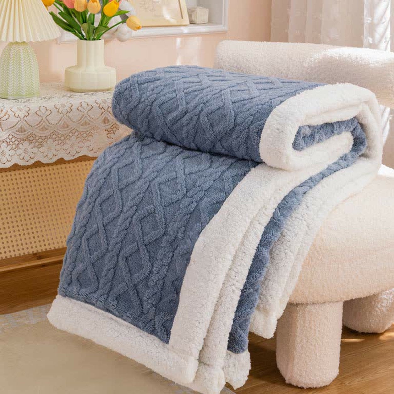 Blue sherpa throw blanket folded, the raised cable and diamond texture facing out