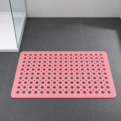 A pink shower mat on a gray tiled bathroom floor beside a bath