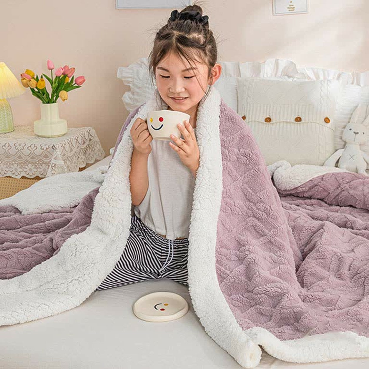 The mauve sherpa throw blanket wrapped around the shoulders