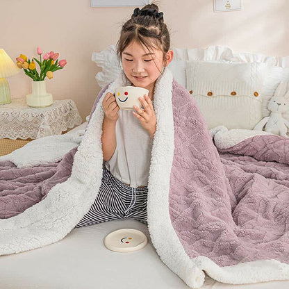 The mauve sherpa throw blanket wrapped around the shoulders