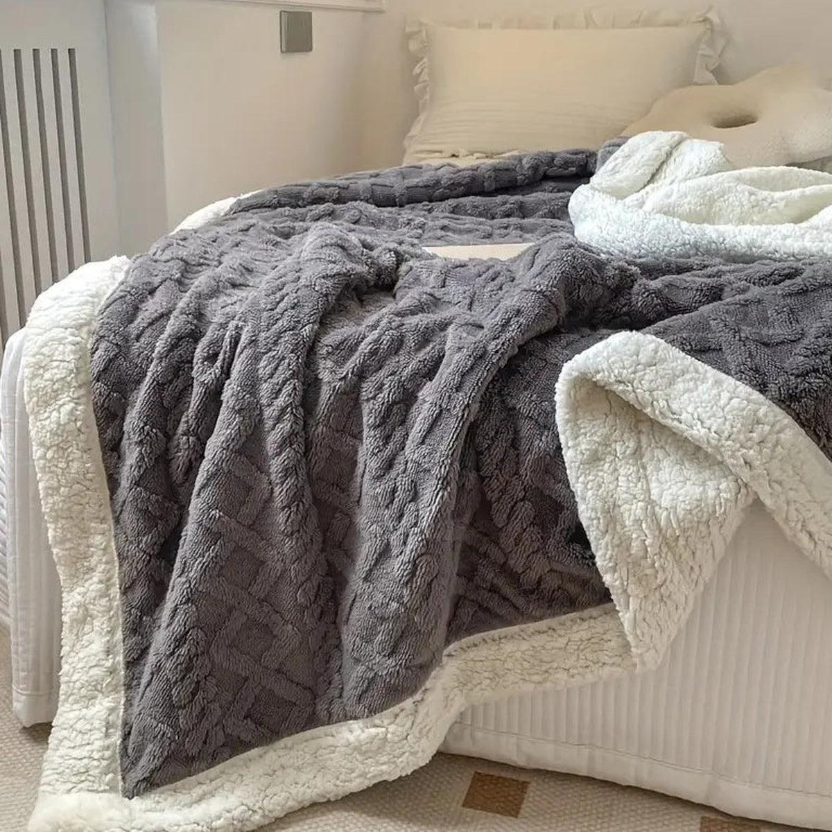 The blanket over a bed with the white sherpa lining turned open beside the textured front