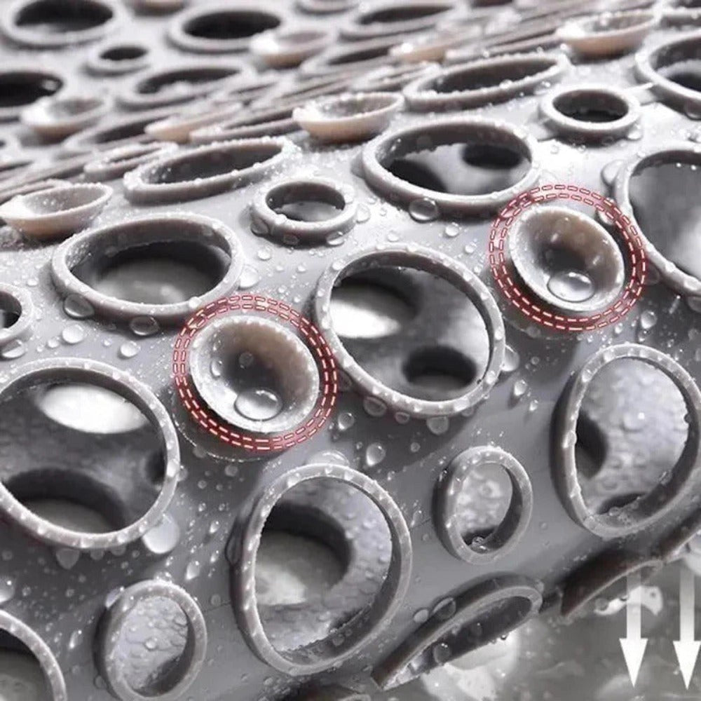 Close-up of the wet underside of the mat, showing the field of small suction cups and the drainage holes passing through it