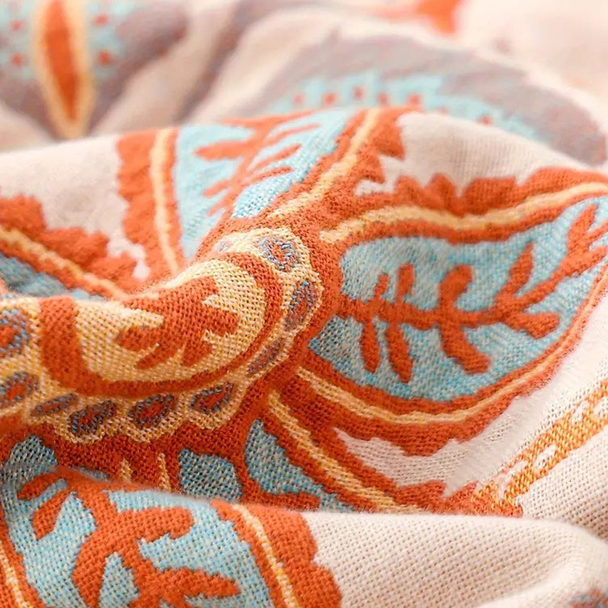 A close photograph of the cream face, with the terracotta, mustard and blue motifs woven into the open cotton ground and the individual threads visible.