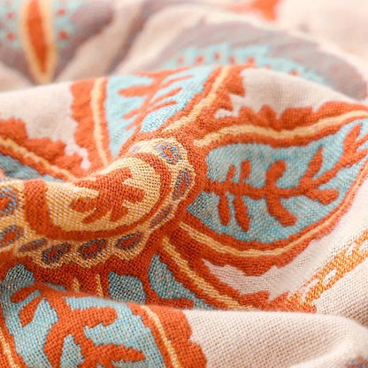 A close photograph of the cream face, with the terracotta, mustard and blue motifs woven into the open cotton ground and the individual threads visible.