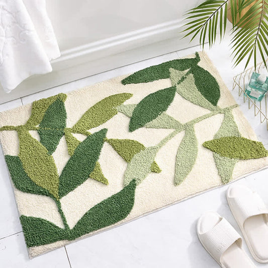 The green leaf mat on a bathroom floor beside a towel rail.